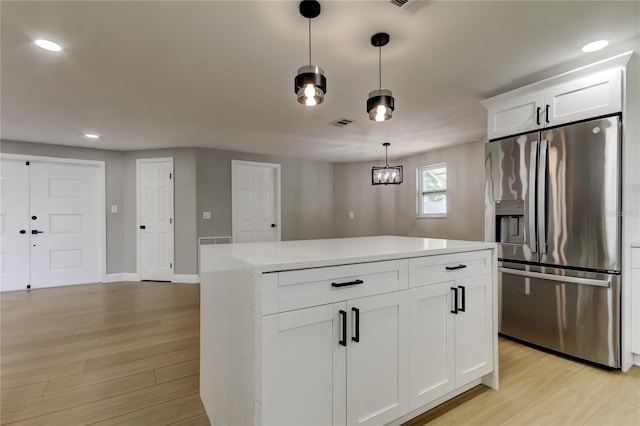 10744 Drummond Rd, Tampa, FL 33615 - kitchen featuring stainless steel fridge with ice dispenser, light wood-type flooring, light countertops, white cabinetry, and recessed lighting