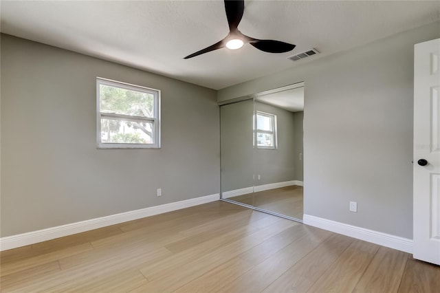 10744 Drummond Rd, Tampa, FL 33615 - unfurnished bedroom with light wood-style floors, multiple windows, a closet, and baseboards
