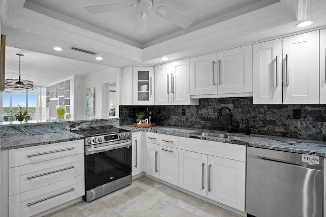 17920 Gulf Blvd Unit 1806, Redington Shores, FL 33708 - kitchen with stainless steel appliances, a sink, a tray ceiling, decorative backsplash, and recessed lighting