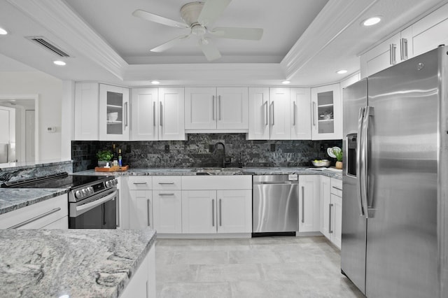 17920 Gulf Blvd Unit 1806, Redington Shores, FL 33708 - kitchen featuring appliances with stainless steel finishes, a sink, a raised ceiling, light stone countertops, and white cabinets