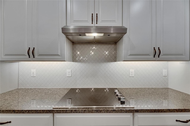 12957 Satin Lily Dr, Riverview, FL 33579 - kitchen with black electric cooktop, tasteful backsplash, under cabinet range hood, and white cabinetry