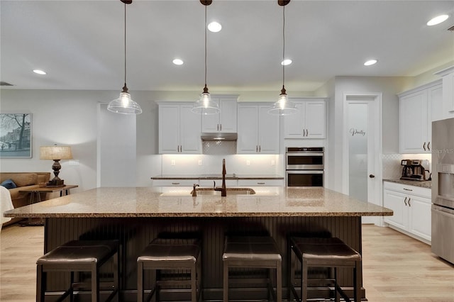 12957 Satin Lily Dr, Riverview, FL 33579 - kitchen with appliances with stainless steel finishes, a sink, tasteful backsplash, white cabinetry, and light stone countertops