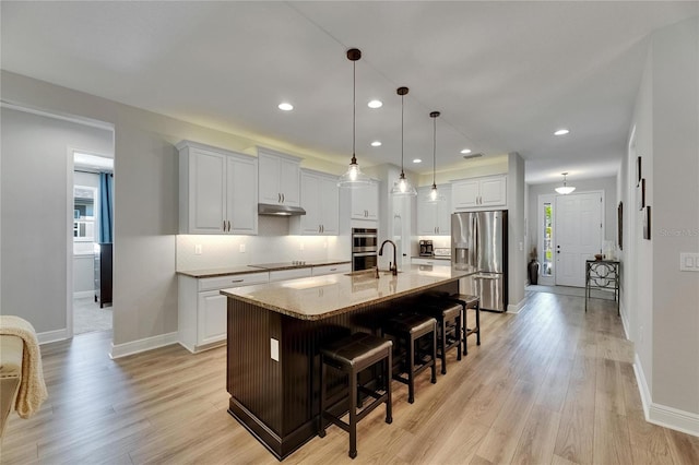 12957 Satin Lily Dr, Riverview, FL 33579 - kitchen with appliances with stainless steel finishes, baseboards, a kitchen breakfast bar, backsplash, and recessed lighting