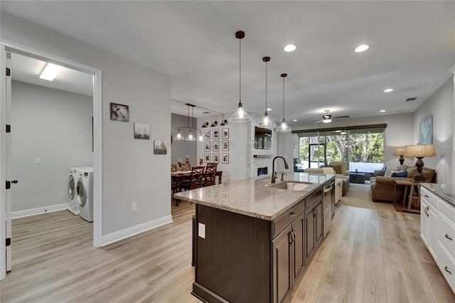 12957 Satin Lily Dr, Riverview, FL 33579 - kitchen featuring separate washer and dryer, a sink, dark brown cabinetry, light wood finished floors, and a ceiling fan