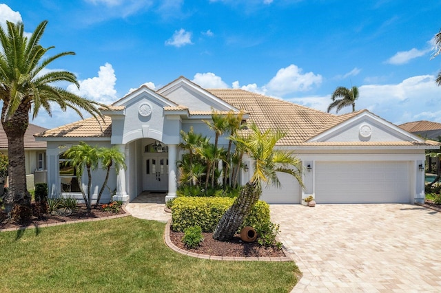 987 Chickadee Dr, Venice, FL 34285 - view of front of property featuring a tile roof, decorative driveway, an attached garage, stucco siding, and a front lawn