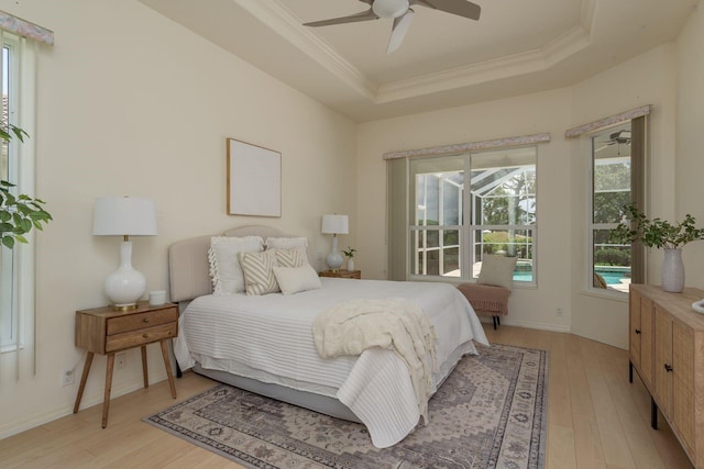 987 Chickadee Dr, Venice, FL 34285 - bedroom featuring a tray ceiling, crown molding, light wood-style floors, multiple windows, and a ceiling fan