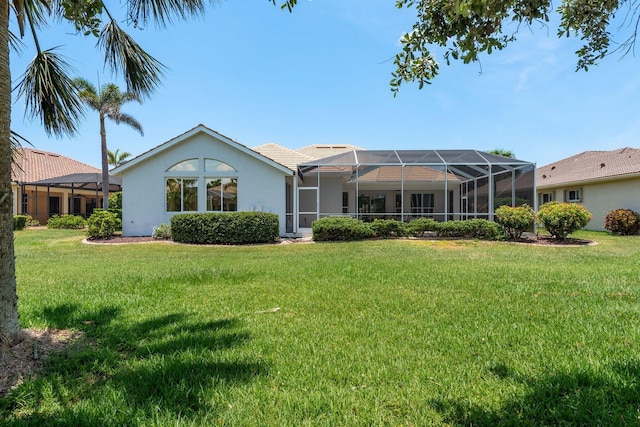 987 Chickadee Dr, Venice, FL 34285 - back of property with a lawn, stucco siding, and glass enclosure
