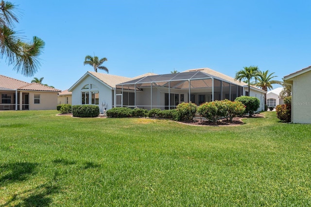 987 Chickadee Dr, Venice, FL 34285 - back of house with a yard, stucco siding, and glass enclosure