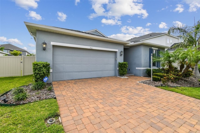 751 Cajeput Loop, Tarpon Springs, FL 34689 - view of front of home featuring stucco siding, decorative driveway, a garage, and a gate