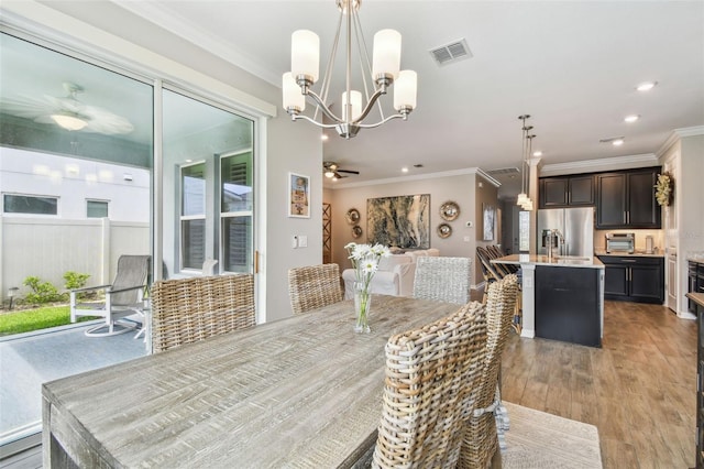 751 Cajeput Loop, Tarpon Springs, FL 34689 - dining area with ceiling fan, a chandelier, crown molding, light wood-type flooring, and recessed lighting
