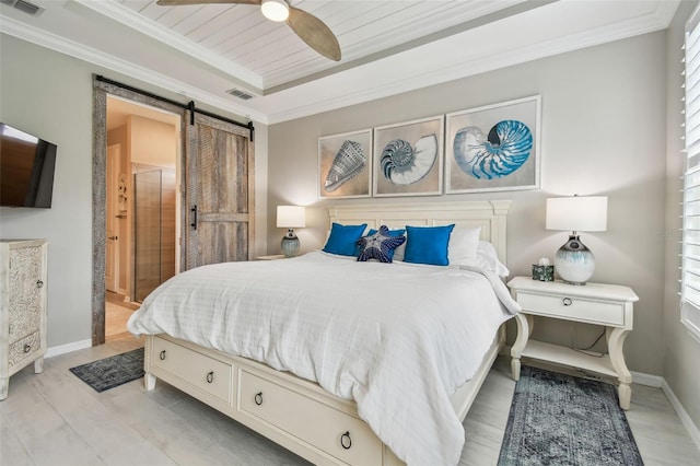 751 Cajeput Loop, Tarpon Springs, FL 34689 - bedroom with a barn door, ornamental molding, baseboards, a tray ceiling, and ceiling fan