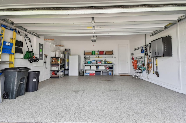 751 Cajeput Loop, Tarpon Springs, FL 34689 - garage featuring freestanding refrigerator, electric water heater, and a garage door opener