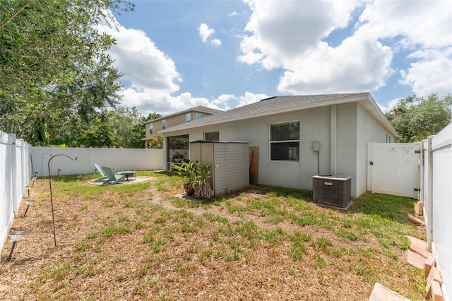 13803 Chalk Hill Pl, Riverview, FL 33579 - rear view of house with a gate, a fenced backyard, central AC, and stucco siding