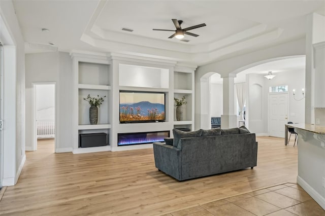 707 9th Ave SW, Ruskin, FL 33570 - living area featuring built in features, a raised ceiling, arched walkways, and a ceiling fan