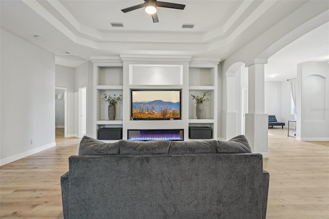 707 9th Ave SW, Ruskin, FL 33570 - living room featuring built in shelves, a tray ceiling, baseboards, and a ceiling fan