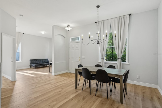 707 9th Ave SW, Ruskin, FL 33570 - dining area with light wood finished floors, plenty of natural light, baseboards, and a chandelier