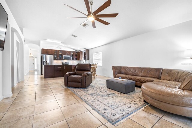 12136 Luftburrow Ln, Hudson, FL 34669 - living area with vaulted ceiling, light tile patterned floors, a ceiling fan, arched walkways, and baseboards