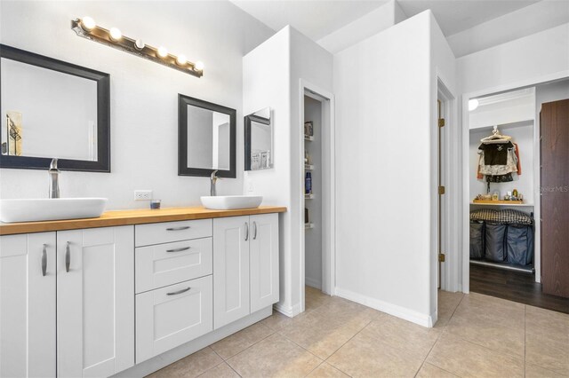 12136 Luftburrow Ln, Hudson, FL 34669 - full bath featuring double vanity, tile patterned flooring, baseboards, and a walk in closet