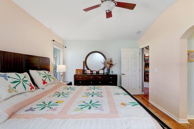 5525 Turtle Crossing Loop, Tampa, FL 33625 - bedroom with arched walkways, wood finished floors, lofted ceiling, ceiling fan, and baseboards
