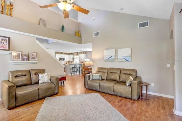 5525 Turtle Crossing Loop, Tampa, FL 33625 - living room featuring ceiling fan, high vaulted ceiling, light wood-type flooring, and baseboards