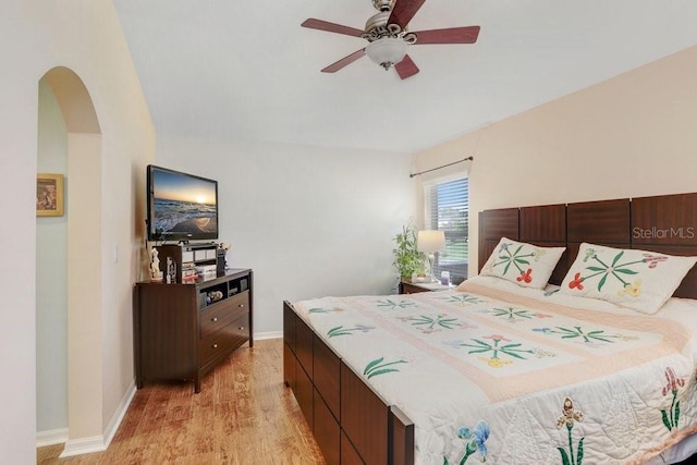 5525 Turtle Crossing Loop, Tampa, FL 33625 - bedroom with light wood-style flooring, arched walkways, baseboards, and ceiling fan