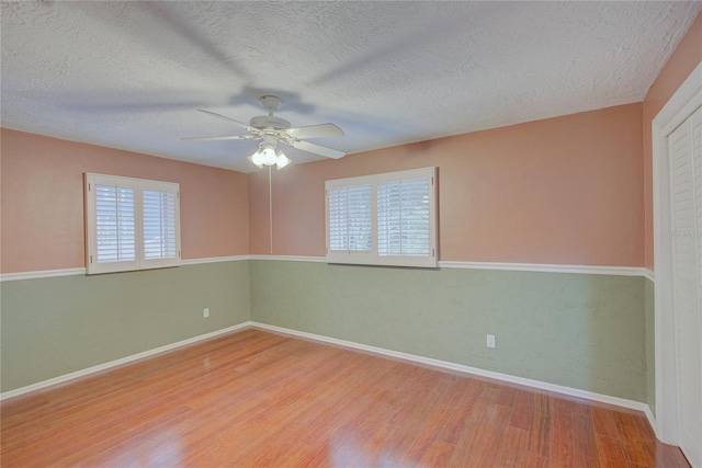 31 Freshwater Dr, Palm Harbor, FL 34684 - empty room featuring wood finished floors, a ceiling fan, a textured ceiling, and baseboards