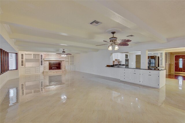31 Freshwater Dr, Palm Harbor, FL 34684 - unfurnished living room with a ceiling fan, beam ceiling, a fireplace, baseboards, and a sink