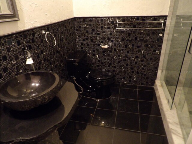 31 Freshwater Dr, Palm Harbor, FL 34684 - full bathroom with toilet, tile walls, a shower stall, tile patterned flooring, and a sink