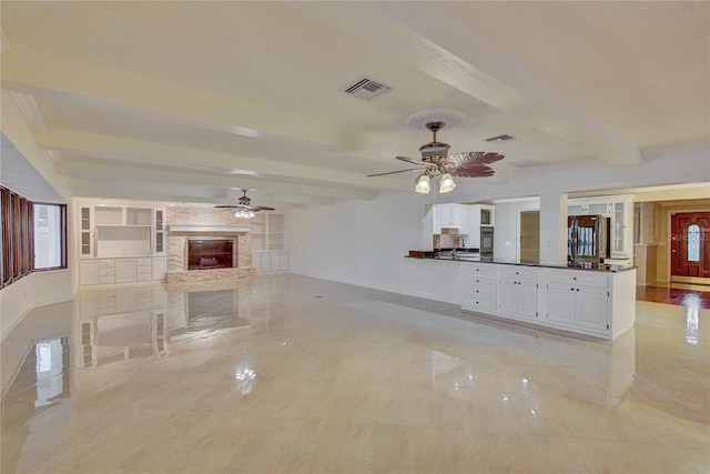 31 Freshwater Dr, Palm Harbor, FL 34684 - unfurnished living room featuring a ceiling fan, beam ceiling, a stone fireplace, baseboards, and a sink