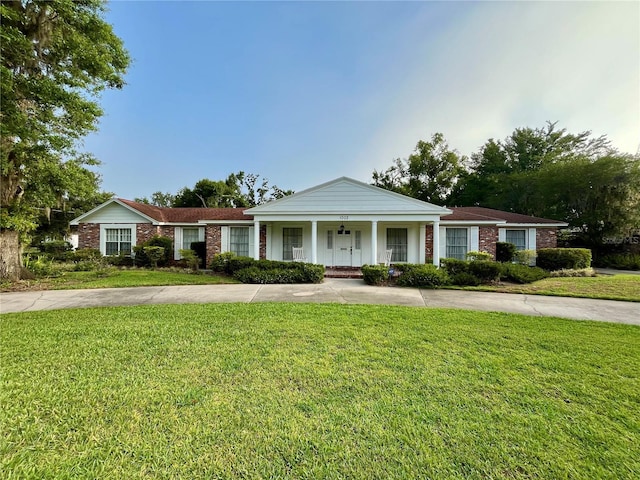 1002 W Pinedale Dr, Plant City, FL 33563 - view of front of house featuring covered porch, a front yard, and brick siding