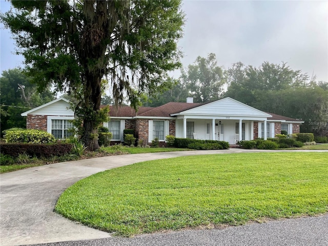1002 W Pinedale Dr, Plant City, FL 33563 - ranch-style house with a front lawn, a porch, and a chimney