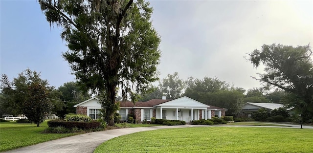 1002 W Pinedale Dr, Plant City, FL 33563 - view of front of house with a front lawn, curved driveway, a chimney, and brick siding