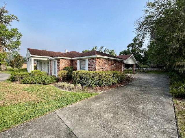 1002 W Pinedale Dr, Plant City, FL 33563 - view of home's exterior with concrete driveway, brick siding, and a lawn