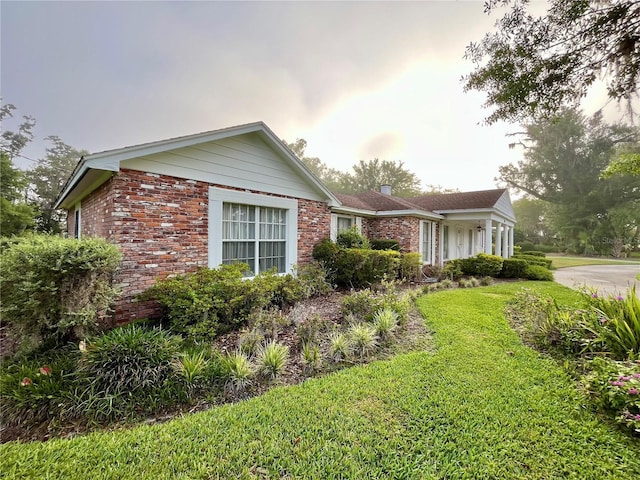 1002 W Pinedale Dr, Plant City, FL 33563 - view of home's exterior featuring a lawn and brick siding
