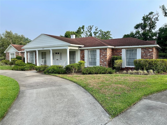 1002 W Pinedale Dr, Plant City, FL 33563 - view of front of house featuring covered porch, a front lawn, brick siding, and concrete driveway