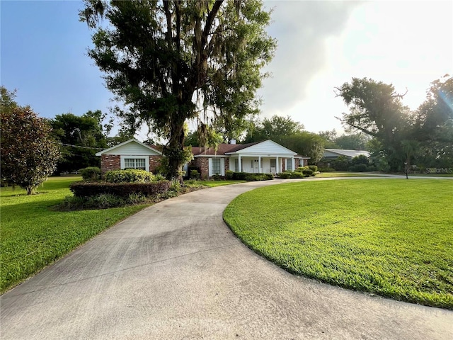 1002 W Pinedale Dr, Plant City, FL 33563 - ranch-style home featuring a front yard, curved driveway, and brick siding