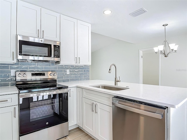 34 Aaron Cir, Ormond Beach, FL 32174 - kitchen featuring stainless steel appliances, a sink, a peninsula, light countertops, and decorative backsplash