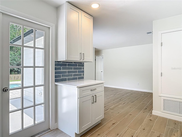 34 Aaron Cir, Ormond Beach, FL 32174 - kitchen featuring light wood-style flooring, light countertops, baseboards, and backsplash