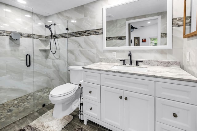 9611 107th Ave N, Largo, FL 33773 - bathroom featuring tile walls, vanity, a shower stall, toilet, and a ceiling fan