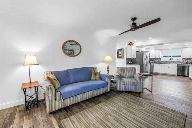 9611 107th Ave N, Largo, FL 33773 - living room with a ceiling fan, a textured ceiling, wood-type flooring, and baseboards