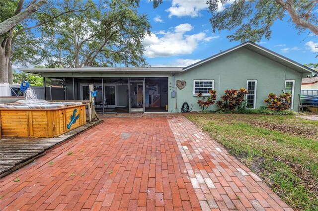 9611 107th Ave N, Largo, FL 33773 - back of house with a sunroom, a hot tub, stucco siding, a patio, and ceiling fan