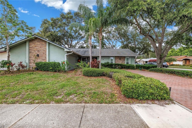 9611 107th Ave N, Largo, FL 33773 - view of front of home with stucco siding, stone siding, and a front yard