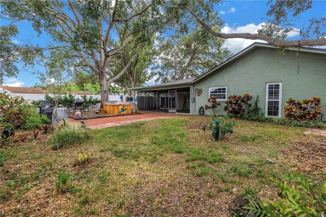 9611 107th Ave N, Largo, FL 33773 - back of property with a sunroom, a hot tub, stucco siding, and a patio area