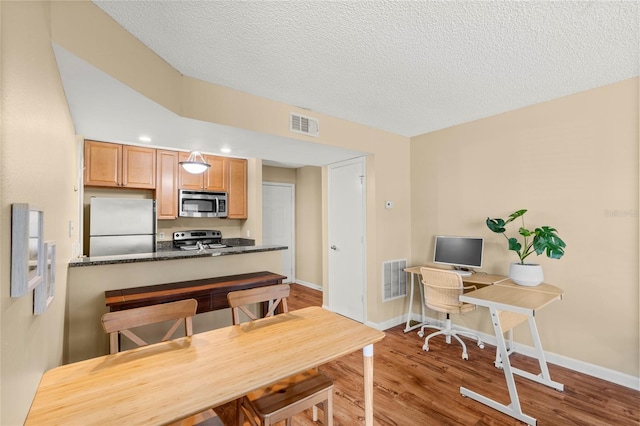 11901 4th St N Unit 5111, Saint Petersburg, FL 33716 - kitchen featuring stainless steel appliances, wood finished floors, a textured ceiling, baseboards, and an office area
