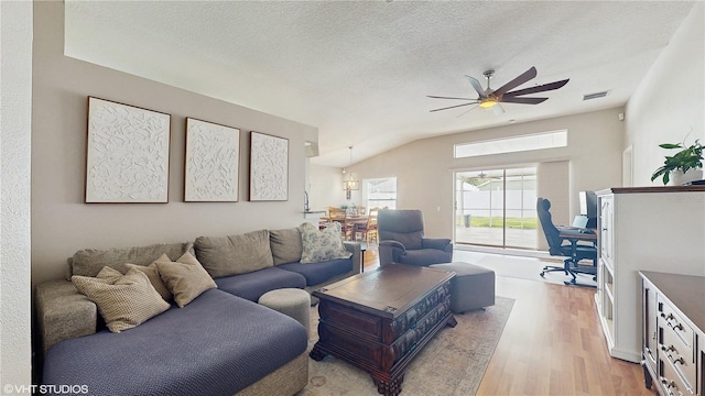 19635 Bellehurst Loop, Land O Lakes, FL 34638 - living area with light wood finished floors, a ceiling fan, a textured ceiling, and vaulted ceiling