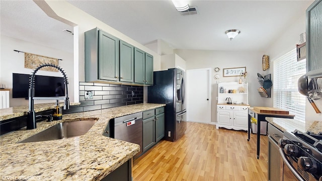 19635 Bellehurst Loop, Land O Lakes, FL 34638 - kitchen featuring a sink, appliances with stainless steel finishes, light stone countertops, decorative backsplash, and light wood-type flooring