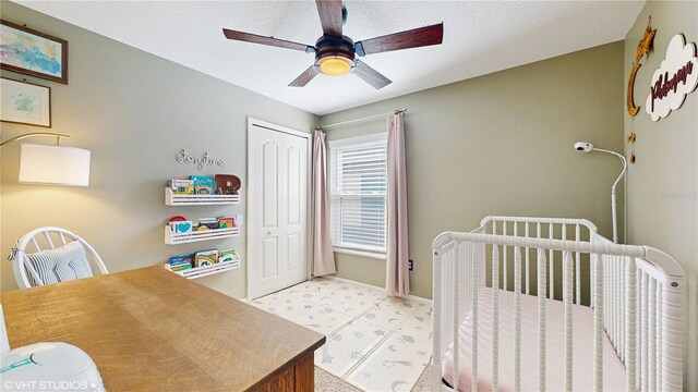 19635 Bellehurst Loop, Land O Lakes, FL 34638 - bedroom with a closet, light flooring, a ceiling fan, a crib, and baseboards