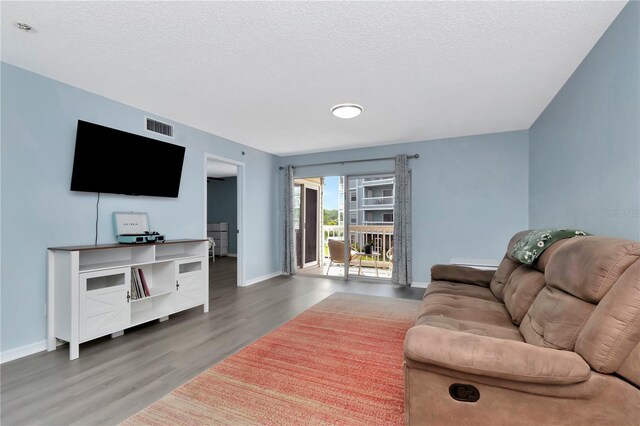 6817 Stones Throw Cir N Unit 17203, Saint Petersburg, FL 33710 - living room with wood finished floors, baseboards, and a textured ceiling