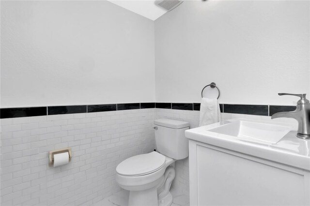6817 Stones Throw Cir N Unit 17203, Saint Petersburg, FL 33710 - half bath featuring toilet, tile walls, vanity, and wainscoting