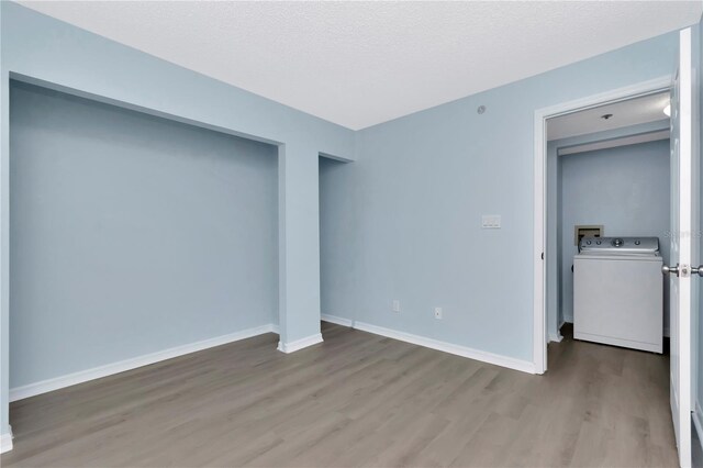 6817 Stones Throw Cir N Unit 17203, Saint Petersburg, FL 33710 - unfurnished bedroom featuring washer / clothes dryer, wood finished floors, baseboards, and a textured ceiling